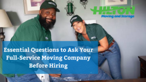 Two smiling movers in green uniforms wrapping furniture with a blue moving blanket with blog title overlaid.