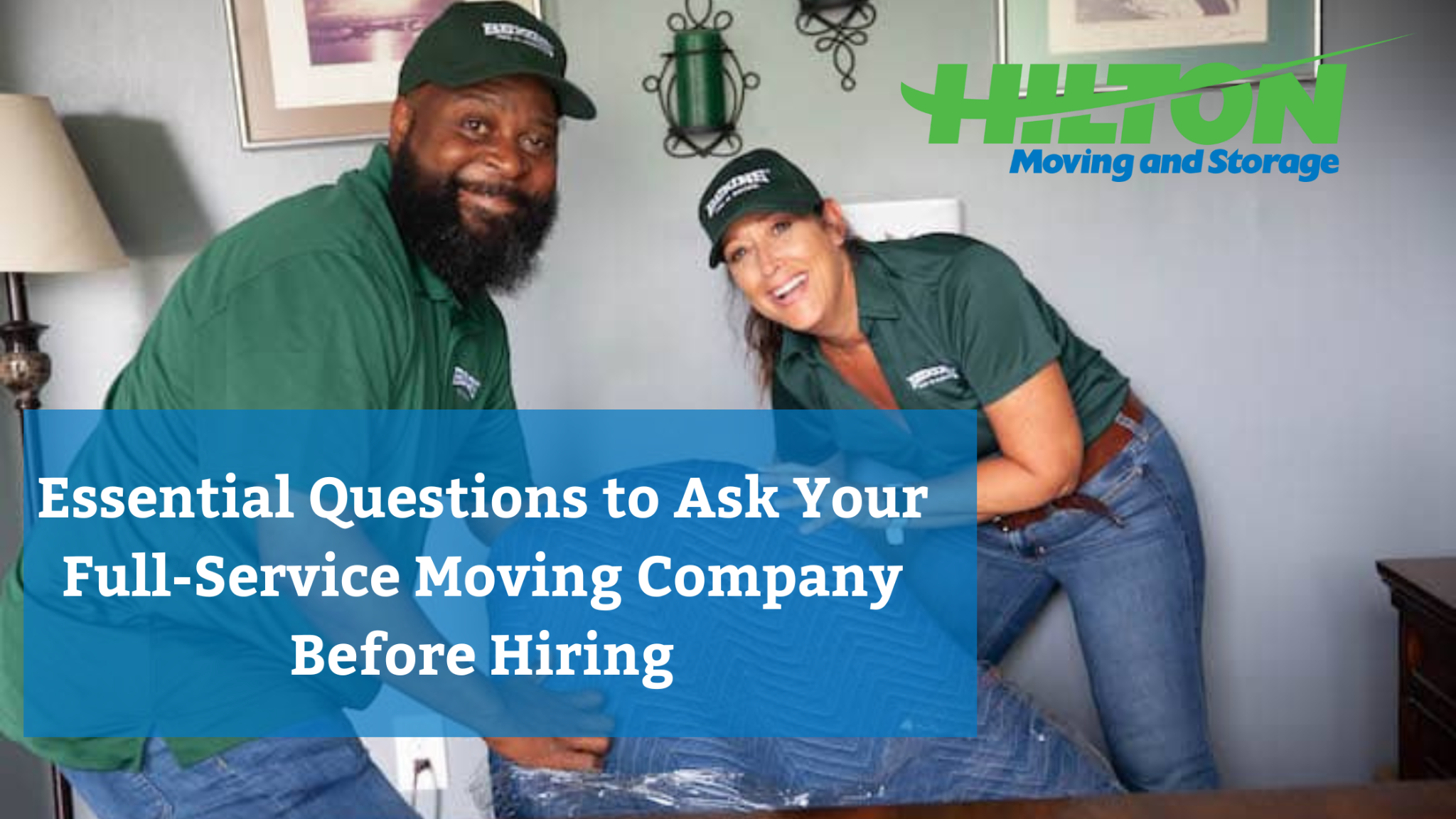Two smiling movers in green uniforms wrapping furniture with a blue moving blanket with blog title overlaid.